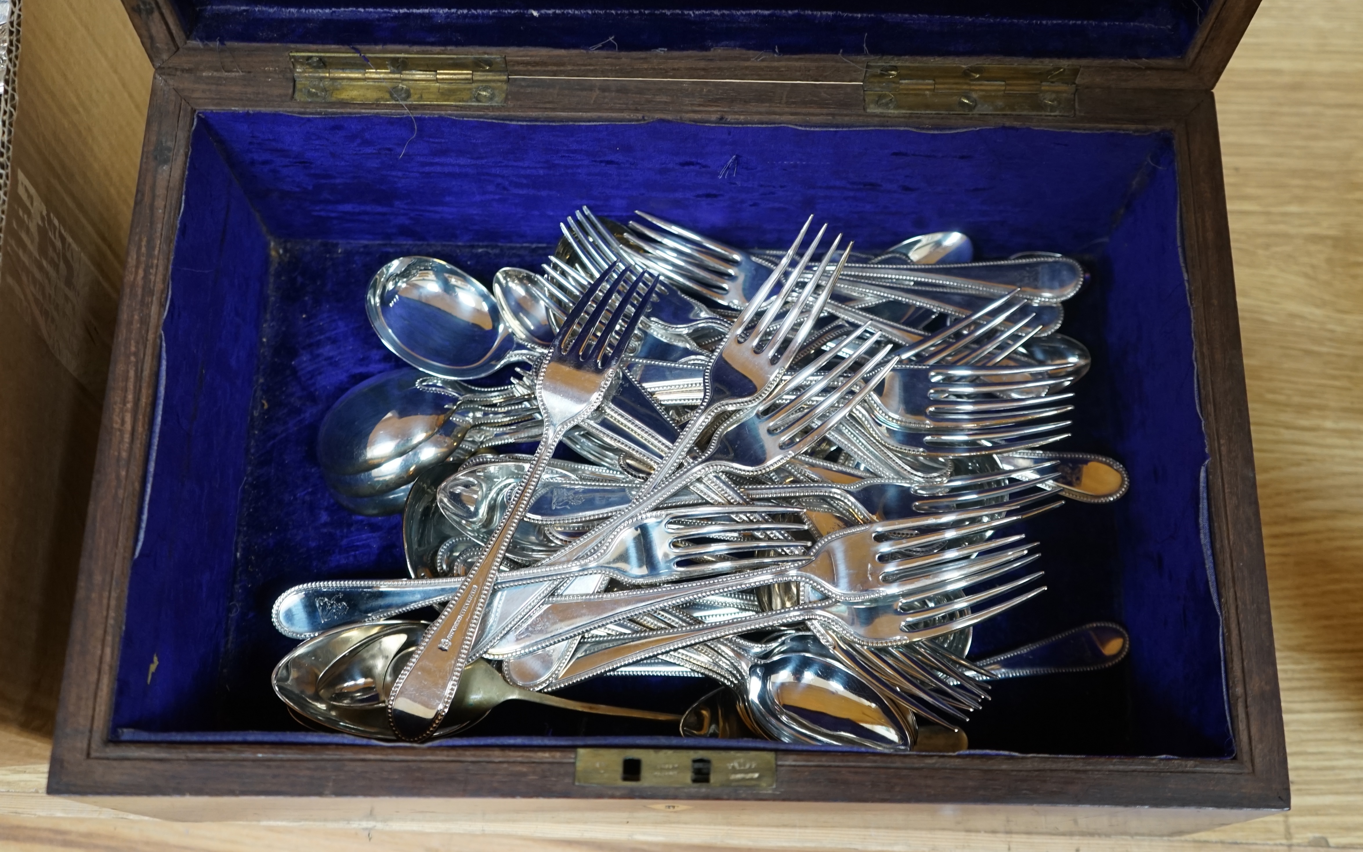 A large quantity silver plated cutlery including a part canteen of King's pattern cutlery and beaded pattern cutlery, a plated sugar basket, together with a mahogany, velvet lined box, 38cm wide. Condition - fair